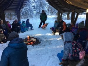 JCCS students sitting around the outdoor camp fire