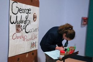 A Crawford ES student shows how agricultural scientist and inventor George Washington Carver developed products with peanuts. 