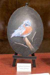 Oval canvas with a bird painting.