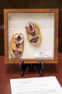 Beaded moosehide baby booties with purple flowers.